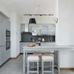 Nowoczesne stołki barowe w stylowej kuchni z wyspą kuchenną