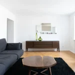 Przedstawienie optycznego powiększenia salonu z wykorzystaniem jasnych kolorów, lustra i inteligentnego rozmieszczenia mebli